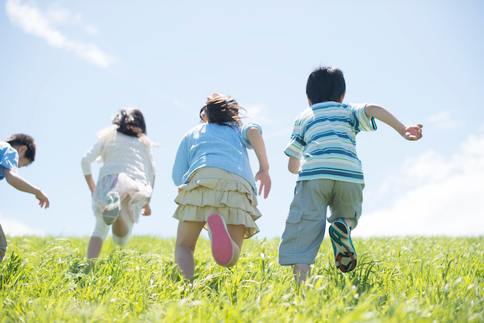 草原を走る小学生の後姿