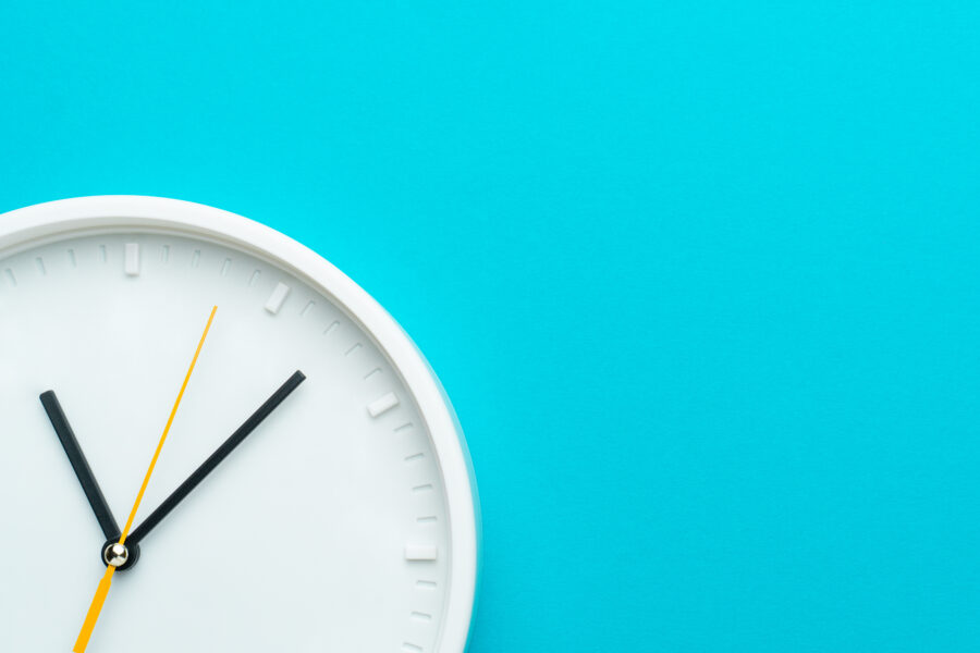 Photo of part of white wall clock over turquiose blue background with copy space
